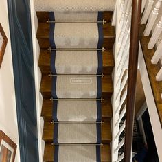 a stair case with blue and white striped rugs on the bottom, along with two framed pictures