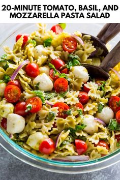 pasta salad with tomatoes, mozzarella and basil in a glass bowl