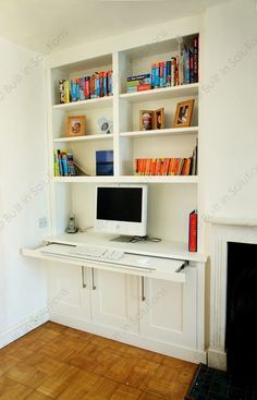 a white desk with a computer on top of it in front of a fire place