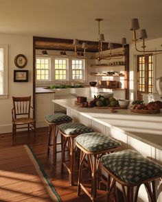 a kitchen filled with lots of counter top space and wooden stools next to an island