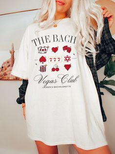 a woman wearing a white t - shirt that says the beach vegas club with casino symbols on it