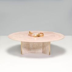 a marble table with two gold rings on it's top and an empty bowl in the middle