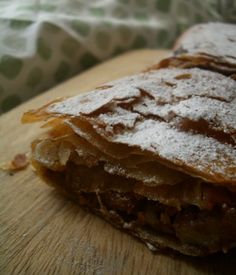 two pieces of food sitting on top of a cutting board covered in powdered sugar