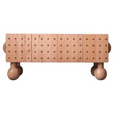 a wooden bench with three balls on it's legs and two wheels attached to the back