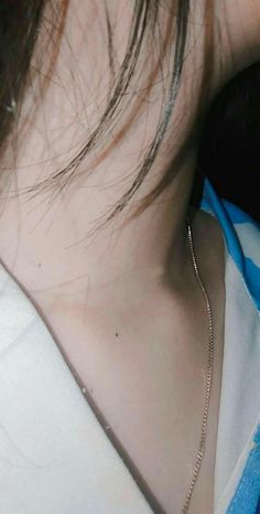 a close up of a person wearing a necklace with a chain on it's neck