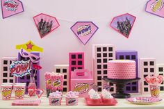 a table topped with lots of pink and purple decorations