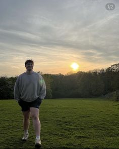 a man standing on top of a lush green field