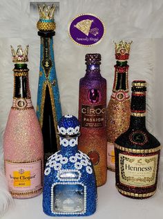 there are many different colored bottles on the table and one has a crown on it