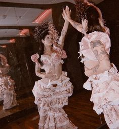 two women dressed in pink and white are dancing