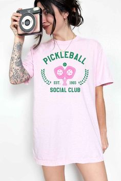 Pickleball Social Club graphic t-shirt Premium cottonUnisex sizing Classic Fit Elevate your pickleball game with our PICKLEBALL SOCIAL CLUB GRAPHIC TEE. Designed for the ultimate social player, this tee features a bold graphic print and a comfortable fit. Join the club and hit the court in style. Fabric Contents: 100% Cotton Sporty T-shirt For Pickleball In Summer, Sporty T-shirt For Summer Pickleball, Pickleball Sports Season Graphic Print T-shirt, Pickleball Sports Season Graphic T-shirt, Pickleball Graphic Tee With Screen Print, Oversized Graphic Tee, Pink Sand, Social Club, Oversized Sweatshirt