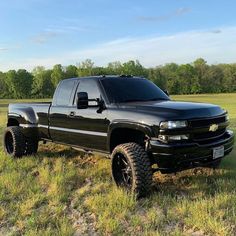 a black truck parked in the middle of a field