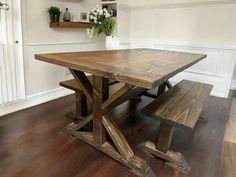 a wooden table with two benches next to it on a hard wood floored room