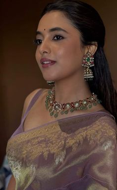 a woman in a sari with jewelry on her neck