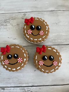 three decorated cookies sitting on top of a wooden table