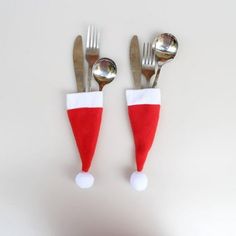 two forks and spoons with santa hats on them