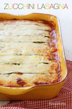 a casserole dish with zucchini in it on a red and white checkered table cloth