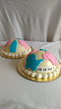 two decorated cakes sitting on top of a white sheet covered bed next to each other