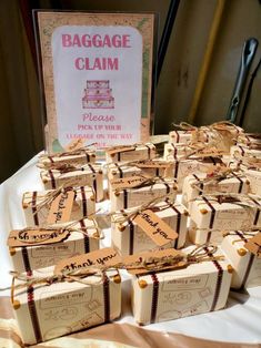 small packages of luggage claim sitting on a table next to a sign that says baggage claim