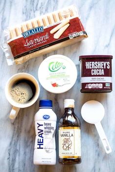 ingredients to make an ice cream sandwich laid out on a marble counter top, including eggs, milk, sugar, and cinnamon sticks