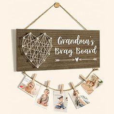 a wooden sign hanging from a rope with photos on it and the words grandma's baby board