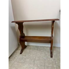 a wooden shelf sitting on top of a tiled floor