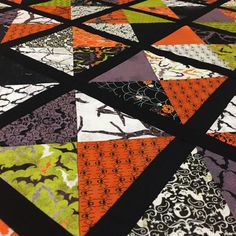 an orange and black patchwork quilt with different patterns