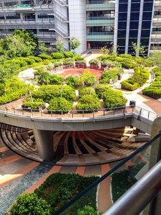 an aerial view of a circular garden with trees in the center and buildings in the background