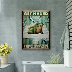 a bathroom with a frog sitting on the toilet and an advertisement above it that says get naked unless you have nothing don't make it weird