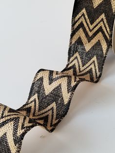 a close up of a black and tan patterned ribbon