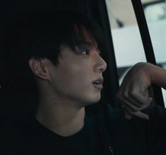 a young man sitting in the back seat of a car