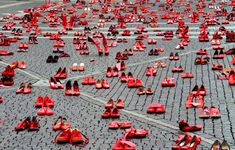 many pairs of red shoes laying on the ground