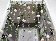 white flowers and greenery hanging from the ceiling