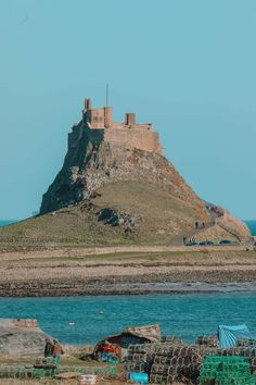 an old castle on top of a hill next to the ocean