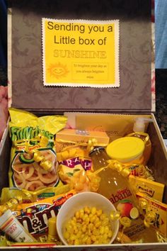 a box filled with snacks and candy sitting on top of a table next to a sign