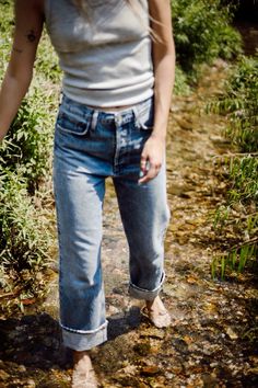 a woman standing in the middle of a stream