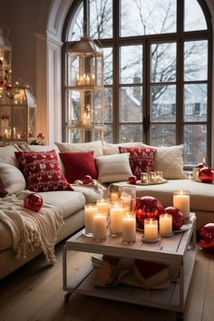 a living room filled with lots of candles next to a couch and table in front of a large window