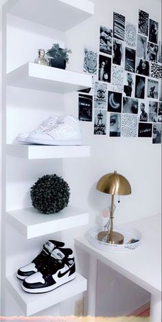 a white desk topped with lots of shelves filled with shoes and pictures on the wall