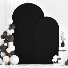 black and white balloons are in front of an arch, with one balloon stuck to the wall