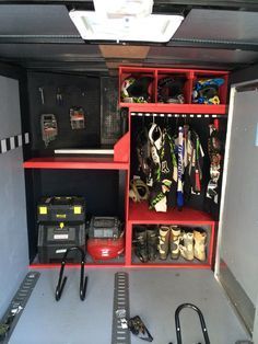 a red shelf filled with lots of sports gear and equipment on top of it's sides