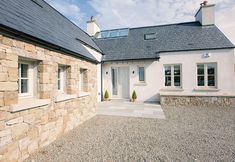 a house with stone walls and windows on the outside