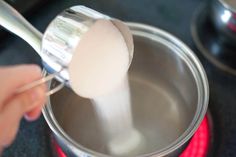 a person is stirring something in a saucepan