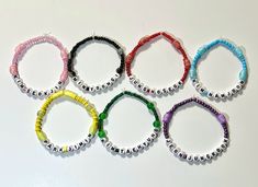 six different colored bracelets with beads on them