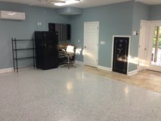 an empty room with two refrigerators and a computer on the desk in front of it