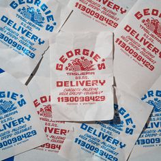 several white paper bags with red and blue designs on them are stacked together in a pile