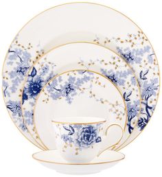 a blue and white china dinnerware set with flowers on the plate, cups and saucers