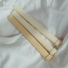 two wooden sticks laying on top of a white sheet