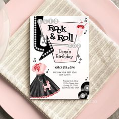 a pink and white table setting with a rock and roll birthday party card on it