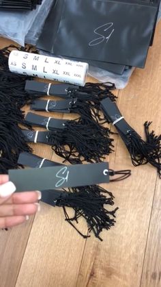 someone is holding scissors on the floor near some black cords and other items that have been placed around them