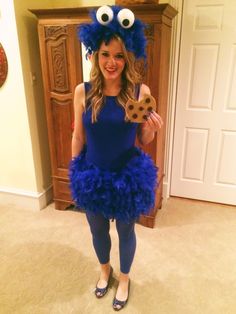 a woman in a cookie monster costume holding a cookie