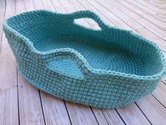 a crocheted basket sitting on top of a wooden floor